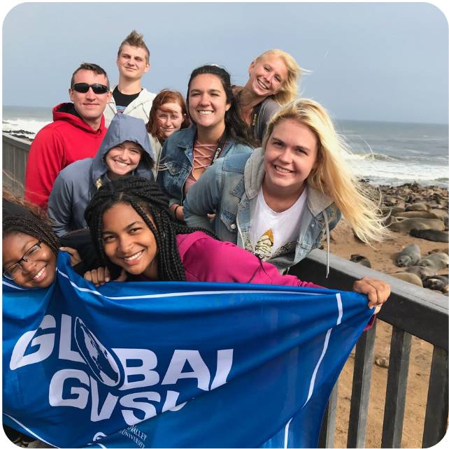 Students with GVSU flag during study abroad trip to Namibia